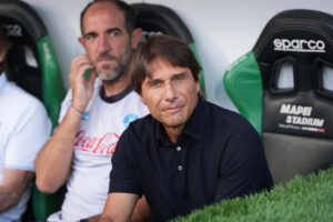 Antonio Conte in primo piano e seduto in panchina