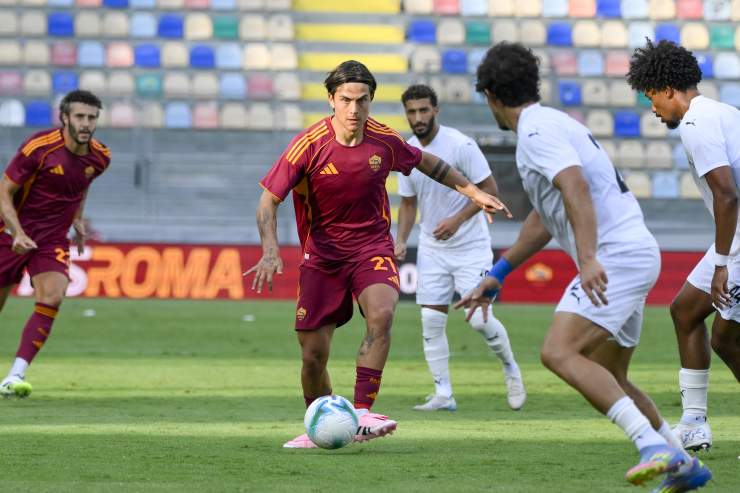 Paulo Dybala con il pallone tra i piedi in mezzo a tre avversari